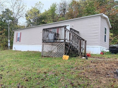 Back of house with a deck, stairway, a yard, and view of scattered trees