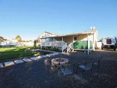 Rear view of property featuring an outdoor fire pit, a porch, and a ceiling fan