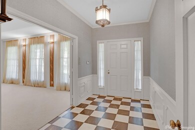 Entry with elegant lighting, wainscot walls and ma