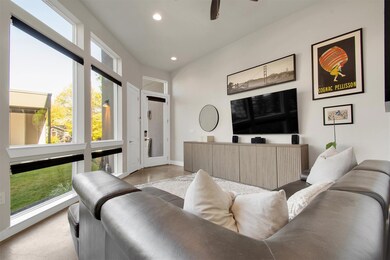 Living Room – Bright and spacious with 14’ ceilings, polished concrete floors, and large windows that fill the space with natural light. The open layout flows seamlessly to the kitchen and patio for easy entertaining and everyday comfort.