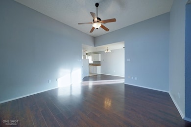Unfurnished room with wood-type flooring, ceiling fan, and a textured ceiling