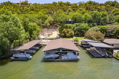 Dock featuring boat lift, a view of trees, and a water view