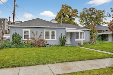 Single story home featuring stucco siding, a front yard, and a shingled roof