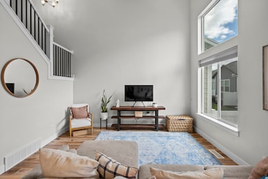 Living area featuring wood finished floors and a towering ceiling