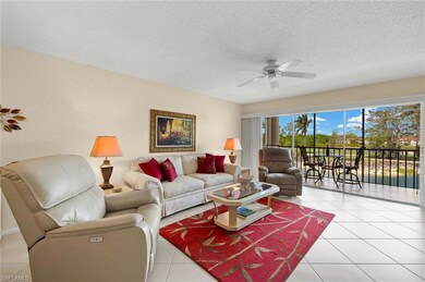 Living area with a textured ceiling, ceiling fan, and light tile patterned floors