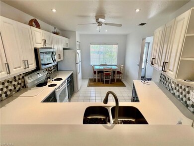 Kitchen featuring a ceiling fan, tasteful backspla