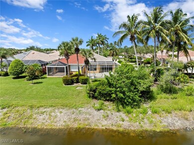 Back of house with a water view, a lawn, glass enc