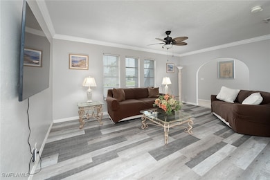 Living room with molding, tile floors, and ceiling