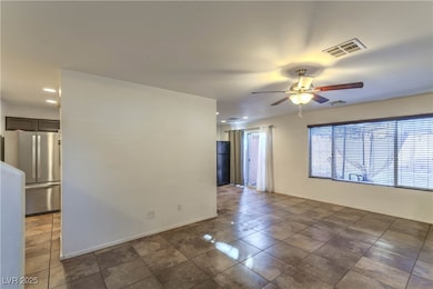 Empty room with a ceiling fan, recessed lighting, and dark tile patterned floors