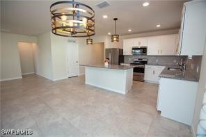 Kitchen with stainless steel appliances, a chandel