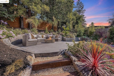 Patio terrace at dusk with a fire pit, a fenced backyard, and a patio area
