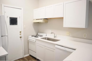 Kitchen featuring white appliances, extractor fan