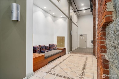Foyer with exposed brick, seating & bank of mail boxes. Stairwell accesses all floors and rooftop deck.