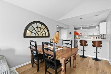 Dining room with light wood-style floors and track lighting