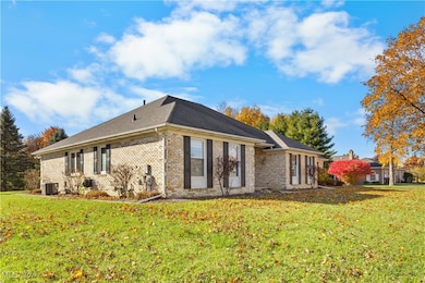 Back of house featuring brick siding and a lawn