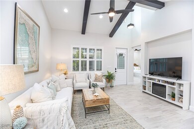 Living room featuring beam ceiling, high vaulted c