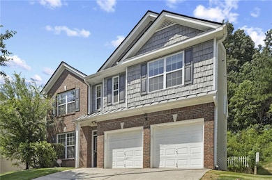 View of front of home featuring brick siding, an attached garage, driveway, and a standing seam roof