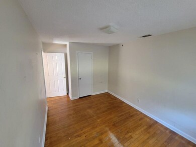 Unfurnished bedroom featuring hardwood / wood-style flooring and a textured ceiling