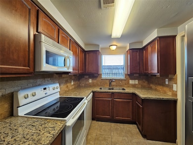 Step into your culinary sanctuary, where thoughtful design and modern amenities create an inviting space for cooking and entertaining. The kitchen showcases a sleek granite countertop that provides a durable and attractive workspace for meal preparation.