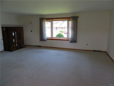 Larger living room with nice window and light coming in.