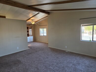 Empty room featuring dark carpet, healthy amount of natural light, and ceiling fan
