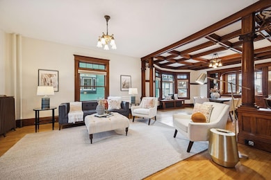 Spacious formal living room and dining room with original chandeliers and newer transom windows