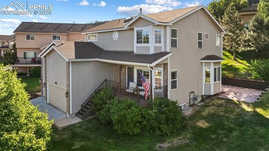 View of front of home featuring a front lawn, a shingled roof, a garage, and a patio area