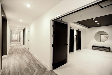 Hall with baseboards, elevator, light wood-style f