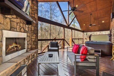 Deck featuring an outdoor stone fireplace, grilling area, and a ceiling fan