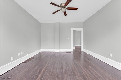 Spare room with wood finished floors, visible vents, a ceiling fan, and baseboards