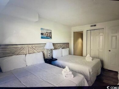 Bedroom with visible vents, a closet, and wood fin