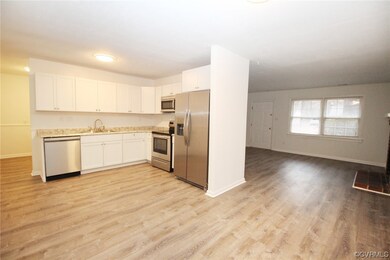 Kitchen with sink, light hardwood / wood-style floors, white cabinetry, and appliances with stainless steel finishes