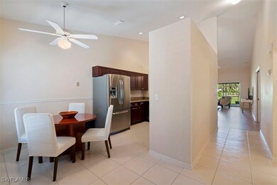 Dining room with high vaulted ceiling, light tile