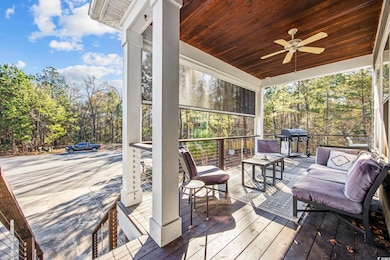 Wooden terrace with outdoor lounge area, ceiling fan, and area for grilling