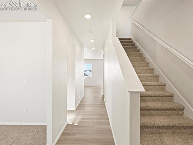 Stairway with recessed lighting, baseboards, and w
