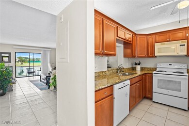 Kitchen with light stone counters, a ceiling fan,