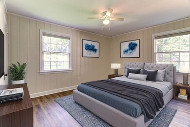 Bedroom featuring crown molding, multiple windows, wood finished floors, and a ceiling fan