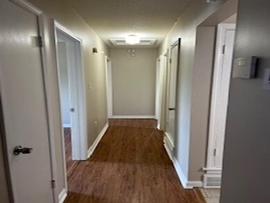 Corridor with a textured ceiling and hardwood / wo
