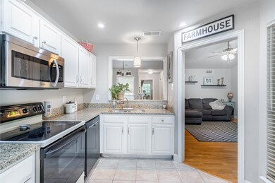 Kitchen with stainless steel appliances, sink, lig
