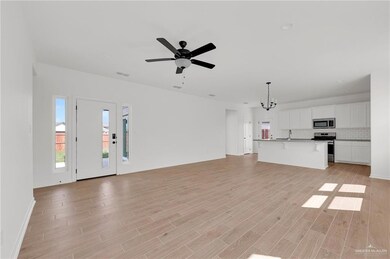 Unfurnished living room with a chandelier, light wood-style floors, and a ceiling fan