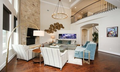 The heart of the home is this double height living room with stone fireplace and beautiful chandelier. This house entertains beautifully