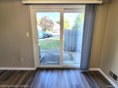 Doorway to outside with wood finished floors and baseboards