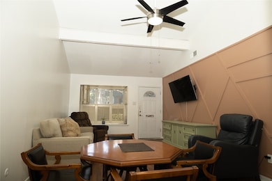 Living room featuring a decorative wall and a ceiling fan