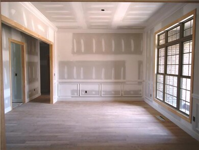 The formal dining room has a 10 ft. ceiling, triple transom windows and wainscotting.