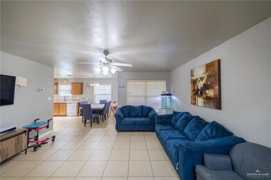 Living room with ceiling fan and light tile flooring