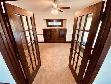 Corridor with light colored carpet and french doors