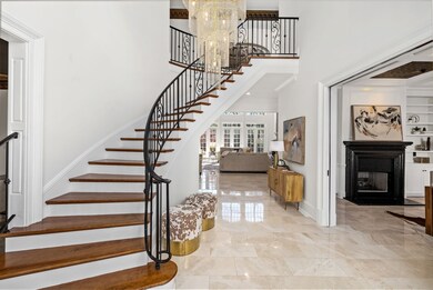 The curved staircase accentuates the bold and beautiful entryway chandelier which is just as incredible lit during the day and night.