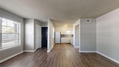 Unfurnished living room featuring dark wood-style floors and a textured ceiling