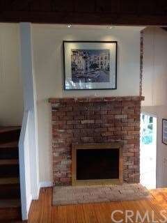 LIVING ROOM FIREPLACE. WOODEN STAIRS ON LEFT TO MA
