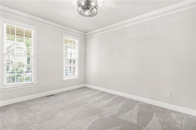 Spare room with ornamental molding, healthy amount of natural light, and carpet